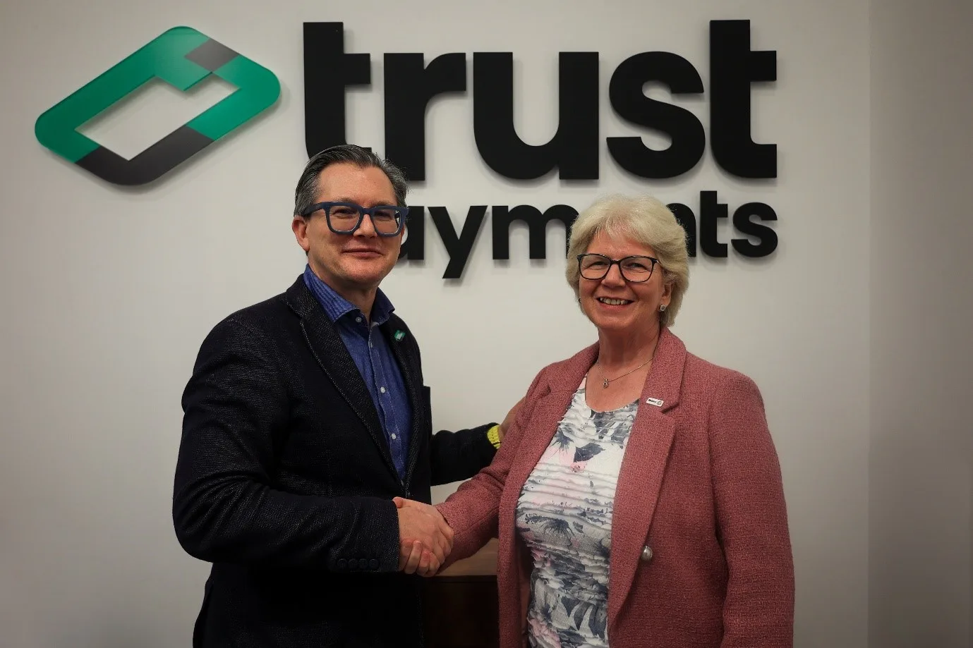Daniel Holden shaking hands with Amanda Watkin at the Trust Payments office