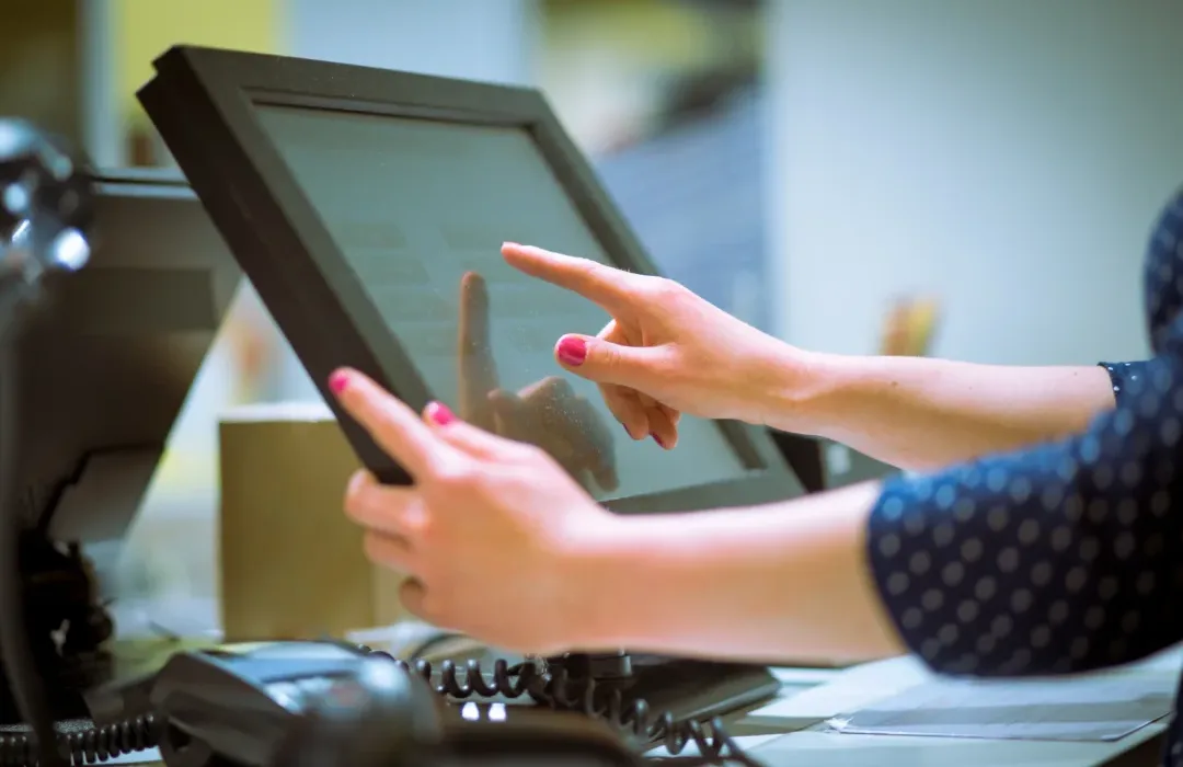 a woman using a touchscreen pos terminal