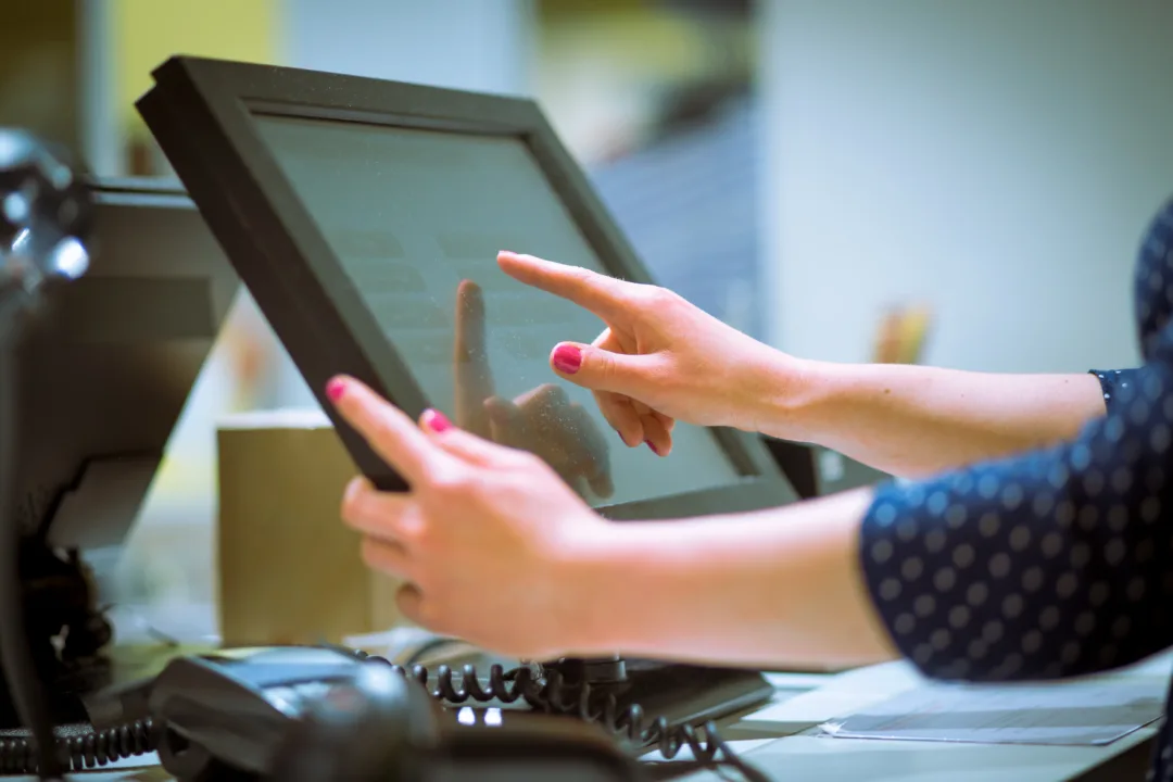 a woman using a touchscreen pos terminal